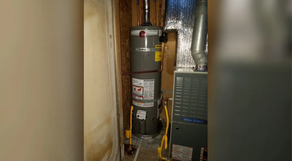 Tank water heater standing in a narrow wooden utility cupboard